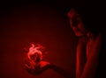 Young girl with a burning heart in the palm