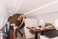 Young girl in the cabin of a business class airplane with a phone in her hands comfortable luxury travel Royalty Free Stock Photo