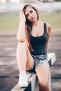 A young girl came to the stadium in the evening to train. The girl sat down to rest