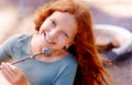 Young girl, camping and marshmallow in portrait with smile, nature and sweet snack in woods. Red hair, teenager and Royalty Free Stock Photo