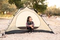 Young girl on camping trip.Child in a tent listening music. Camping. Happy kid at summer vacations. travel, camping for Royalty Free Stock Photo