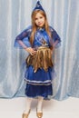 Young girl in a carnival blue suit with a golden belt and golden shoes. Children carnival costume