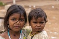 Young girl carries younger siter on her arm, Angadihalli Karnataka India.