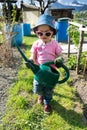 Young girl carrying a large green watering can as she helps in the vegetable garden Royalty Free Stock Photo