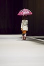 Young girl carrying an umbrella on the catwalk at Momad 2023 Madrid Spain