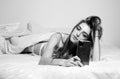 Young girl chatting on phone in the morning in bed. Woman in bed checking social apps with smartphone. Royalty Free Stock Photo