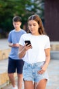 Young girl chatting on smartphone in street Royalty Free Stock Photo