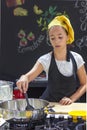 Young girl in a chef`s hat cooks in a large saucepan in a black Royalty Free Stock Photo