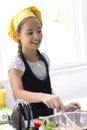 Young girl in a chef`s hat cooks in a large saucepan in a black Royalty Free Stock Photo