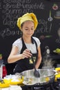 Young girl in a chef`s hat cooks in a large saucepan in a black Royalty Free Stock Photo