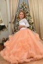 a young girl in a chic white with peach dress