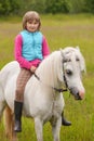 Young girl child sitting astride a white horse Royalty Free Stock Photo