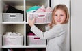 Young girl choosing dress in wardrobe at home. The wardrobe which put in order. All things are folded neatly. Many boxes. Everythi Royalty Free Stock Photo