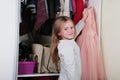 Young girl choosing dress in wardrobe at home. The wardrobe which put in order. All things are folded neatly. Many boxes. Everythi Royalty Free Stock Photo