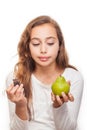 Young girl choosing between fruit and chocolate isolated Royalty Free Stock Photo