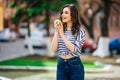 Young girl on the city street with smartphone and eating big apple Royalty Free Stock Photo