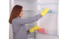 Young girl cleaning empty fridge with a sponge. Royalty Free Stock Photo
