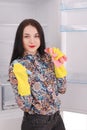 Young girl cleaning empty fridge with a sponge. Royalty Free Stock Photo