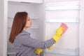 Young girl cleaning empty fridge with a sponge. Royalty Free Stock Photo