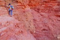 Young girl climber with backpack climbs trail to rocky wall. mountaineering on the route in the Great Red Canyon. Eilat, Isreal