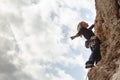 A young girl climber climbs high up the cliff in Geyikbayiri Tur