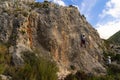 Young girl climber in the middle of a rock wall while her partner belays her from below