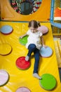 Young girl climbing down ramp in soft play centre