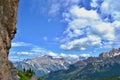 Young girl is climbing on of the routes on Cinque Torri tower. High mountains, blue sky, white clouds.