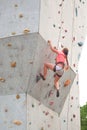 girl climbing up a high wall for rock climbing