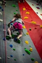 Young girl climbing up on practice wall in indoor rock gym Royalty Free Stock Photo