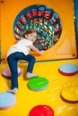 Young girl climbing up ramp into tunnel at soft play centre