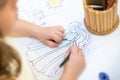 Young girl coloring in coloring book. kids draws birthday party