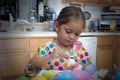 Young girl coloring Easter eggs with color in hand Royalty Free Stock Photo