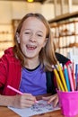 Young girl colouring, smiling Royalty Free Stock Photo