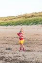 Young girl concentrating on flying her kite on a beach
