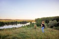 The young girl contemplates the beauty of nature. The girl from the hill looks at the river and the forest_