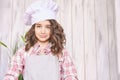 Young girl cooking at kitchen. Curly pretty child portrait. Chef student