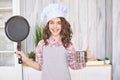 Young girl cooking kitchen. Curly pretty child portrait. Chef christmas student Royalty Free Stock Photo