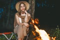 Young girl in cozy warm stylish outfit near fireplace romantic weekend in forest road trip