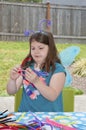 Young girl crafting with pipe cleaners wearing fairy wings Royalty Free Stock Photo