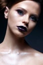 Young girl with creative makeup and hairdo. A beautiful model with bright eyes and purple lips. Shining skin.