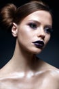 Young girl with creative makeup and hairdo. A beautiful model with bright eyes and purple lips. Shining skin. Royalty Free Stock Photo