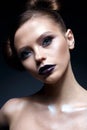 Young girl with creative makeup and hairdo. A beautiful model with bright eyes and purple lips. Shining skin.