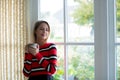 Young girl with cup of coffee stay near window Royalty Free Stock Photo