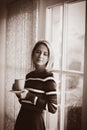 Young girl with cup of coffee stay near window Royalty Free Stock Photo