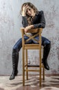 Young girl with curly hair in a black shirt, jeans and high boots cowboy western style Royalty Free Stock Photo