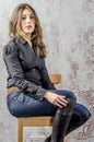 Young girl with curly hair in a black shirt, jeans and high boots cowboy western style Royalty Free Stock Photo