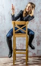 Young girl with curly hair in a black shirt, jeans and high boots cowboy western style