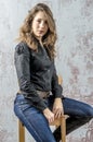 Young girl with curly hair in a black shirt, jeans and high boots cowboy western style Royalty Free Stock Photo