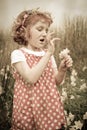 Young girl with curly red hair in field of wildflowers